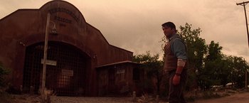 Movie still from “Vampires” (1998), directed by John Carpenter – A man standing in front of an old building; Wide shot, Low angle
