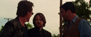 Movie still from “Vampires” (1998), directed by John Carpenter – A group of men standing next to each other on a field; Close Up shot, Over the shoulder angle