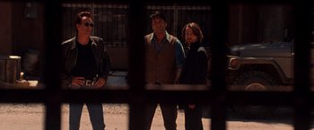 Movie still from “Vampires” (1998), directed by John Carpenter – A group of people standing next to each other on a street; Medium shot, Low angle