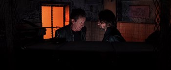 Movie still from “Vampires” (1998), directed by John Carpenter – A couple of men standing next to each other in a room; Medium shot, Over the shoulder angle