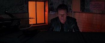 Movie still from “Vampires” (1998), directed by John Carpenter – A man sitting in front of a computer monitor; Medium shot, Low angle