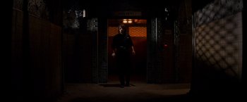 Movie still from “Vampires” (1998), directed by John Carpenter – A person standing in front of an entrance to a building; Wide shot, Low angle