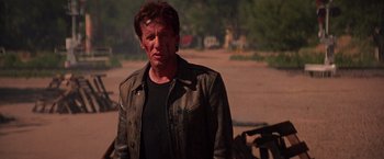 Movie still from “Vampires” (1998), directed by John Carpenter – A man in a leather jacket standing next to a motorcycle; Medium shot, Low angle