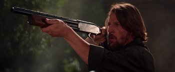 Movie still from “Vampires” (1998), directed by John Carpenter – A person holding a gun; Close Up shot, Low angle