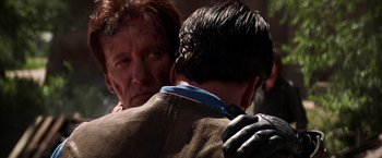 Movie still from “Vampires” (1998), directed by John Carpenter – A man hugging another man with blood all over his face; Close Up shot, Over the shoulder angle