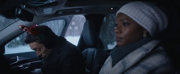 Movie still from “Violent Night” (2022), directed by Tommy Wirkola – A woman sitting in the back seat of a car in the snow; Close Up shot, Over the shoulder angle