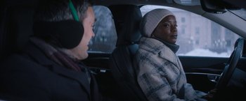Movie still from “Violent Night” (2022), directed by Tommy Wirkola – A man and a woman sitting in the back of a car; Close Up shot, Over the shoulder angle