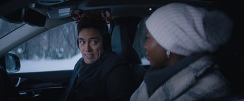 Movie still from “Violent Night” (2022), directed by Tommy Wirkola – A man and a woman sitting in the back of a car; Close Up shot, Over the shoulder angle