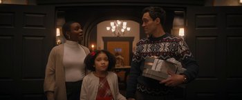 Movie still from “Violent Night” (2022), directed by Tommy Wirkola – A man and a woman and a little girl holding presents; Medium shot, Over the shoulder angle