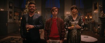 Movie still from “Violent Night” (2022), directed by Tommy Wirkola – A group of people standing next to each other in a room; Medium shot, Low angle