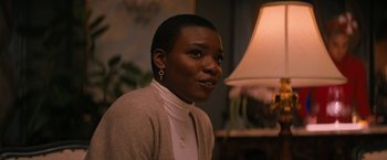 Movie still from “Violent Night” (2022), directed by Tommy Wirkola – A woman with short black hair wearing a sweater; Close Up shot, Over the shoulder angle