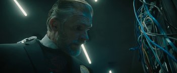 Movie still from “Violent Night” (2022), directed by Tommy Wirkola – A person wearing a suit and tie; Close Up shot, Low angle