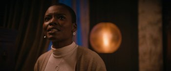 Movie still from “Violent Night” (2022), directed by Tommy Wirkola – A woman with a white shirt is looking at the camera; Close Up shot, Low angle