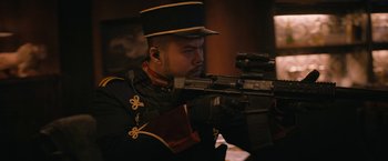 Movie still from “Violent Night” (2022), directed by Tommy Wirkola – A man in a uniform is holding a rifle; Medium shot, Low angle