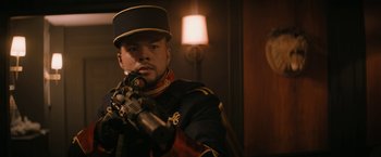 Movie still from “Violent Night” (2022), directed by Tommy Wirkola – A man in a uniform holding a gun; Medium shot, Low angle