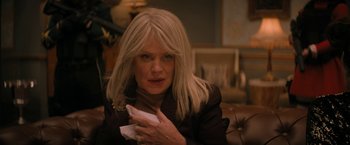 Movie still from “Violent Night” (2022), directed by Tommy Wirkola – A woman holding a cell phone in her hands; Close Up shot, Over the shoulder angle