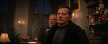 Movie still from “Violent Night” (2022), directed by Tommy Wirkola – Two men standing next to each other in front of a window; Medium shot, Over the shoulder angle