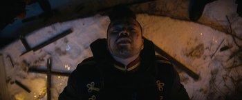 Movie still from “Violent Night” (2022), directed by Tommy Wirkola – A person wearing a military uniform; Close Up shot, Overhead angle