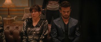 Movie still from “Violent Night” (2022), directed by Tommy Wirkola – A man and a woman sitting next to each other; Medium shot, Over the shoulder angle