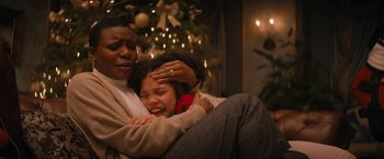 Movie still from “Violent Night” (2022), directed by Tommy Wirkola – A man and a woman sitting in front of a christmas tree; Close Up shot, High angle