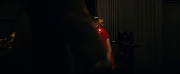 Movie still from “Violent Night” (2022), directed by Tommy Wirkola – A fire extinguisher in a dark room with a blurry background; Medium shot, High angle