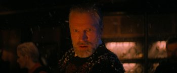 Movie still from “Violent Night” (2022), directed by Tommy Wirkola – A man with a goatee and a beard stares at the camera; Close Up shot, Low angle
