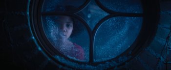 Movie still from “Violent Night” (2022), directed by Tommy Wirkola – A girl is looking out a window at night; Close Up shot, Low angle