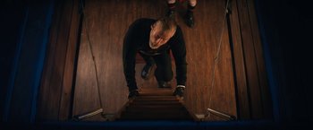 Movie still from “Violent Night” (2022), directed by Tommy Wirkola – A man climbing up a set of stairs; Medium shot, Low angle
