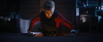 Movie still from “Violent Night” (2022), directed by Tommy Wirkola – A woman in a red shirt is looking down at the floor; Medium shot, Low angle