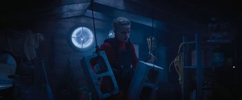 Movie still from “Violent Night” (2022), directed by Tommy Wirkola – A woman in a red shirt holding two concrete blocks; Medium shot, Low angle