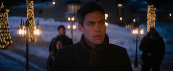 Movie still from “Violent Night” (2022), directed by Tommy Wirkola – A person wearing a suit and tie; Close Up shot, Over the shoulder angle