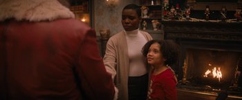 Movie still from “Violent Night” (2022), directed by Tommy Wirkola – A woman standing next to a young girl in front of a mirror; Medium shot, Over the shoulder angle