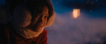 Movie still from “Violent Night” (2022), directed by Tommy Wirkola – A young girl wearing a red coat and a white hat; Close Up shot, Over the shoulder angle
