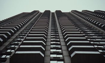 Movie still from “Vox Lux” (2018), directed by Brady Corbet – A very tall building that has many windows; Extreme Wide shot, Low angle