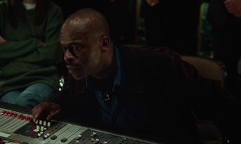 Movie still from “Vox Lux” (2018), directed by Brady Corbet – A man sitting in front of a sound board; Close Up shot, High angle