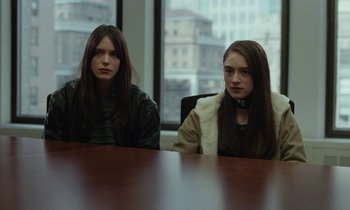 Movie still from “Vox Lux” (2018), directed by Brady Corbet – Two women sitting at a table in front of a window; Medium shot, Over the shoulder angle