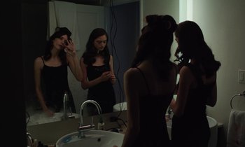 Movie still from “Vox Lux” (2018), directed by Brady Corbet – A group of women standing in front of a bathroom mirror; Medium shot, Over the shoulder angle