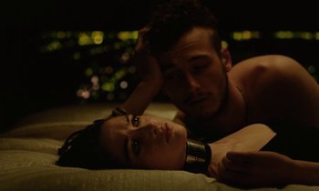 Movie still from “Vox Lux” (2018), directed by Brady Corbet – A man and a woman laying on a bed; Close Up shot, Overhead angle