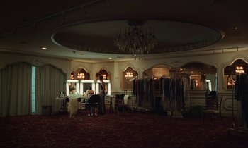 Movie still from “Vox Lux” (2018), directed by Brady Corbet – A room filled with lots of clothes hanging on a rack; Extreme Wide shot, High angle