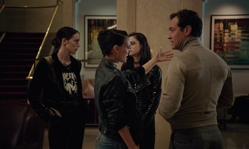 Movie still from “Vox Lux” (2018), directed by Brady Corbet – A group of people standing around talking to each other; Medium shot, Over the shoulder angle