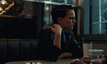 Movie still from “Vox Lux” (2018), directed by Brady Corbet – A person sitting at a table in front of a laptop; Close Up shot, Over the shoulder angle