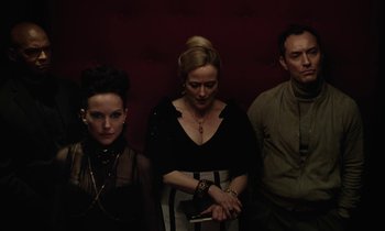 Movie still from “Vox Lux” (2018), directed by Brady Corbet – A group of people standing next to each other in a room; Medium shot, Low angle