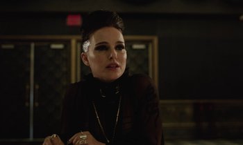 Movie still from “Vox Lux” (2018), directed by Brady Corbet – A woman in a black dress with a white flower in her hair; Close Up shot, Over the shoulder angle
