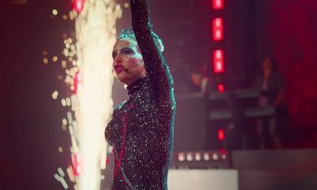 Movie still from “Vox Lux” (2018), directed by Brady Corbet – A woman in a black dress is on a stage; Medium shot, Low angle
