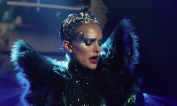 Movie still from “Vox Lux” (2018), directed by Brady Corbet – A woman in a black dress and a black and blue outfit; Close Up shot, Low angle