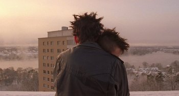 A man and a child standing next to each other in front of a building