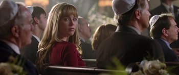 Movie still from “Wedding Crashers” (2005), directed by David Dobkin – A woman sitting on a bench in front of other people; Close Up shot, Over the shoulder angle