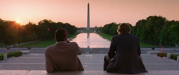 Movie still from “Wedding Crashers” (2005), directed by David Dobkin – Two people sitting on a bench looking at the washington monument at sunset; Wide shot, Over the shoulder angle