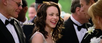 Movie still from “Wedding Crashers” (2005), directed by David Dobkin – A woman with long brown curly hair smiling for the camera; Close Up shot, Over the shoulder angle