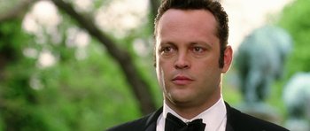 Movie still from “Wedding Crashers” (2005), directed by David Dobkin – A person wearing a suit and a bow tie; Close Up shot, Over the shoulder angle